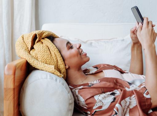 woman in towel learning on phone